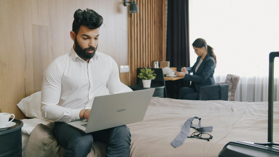 Geschäftsreisender arbeitet abends mit dem Laptop auf dem Hotelbett